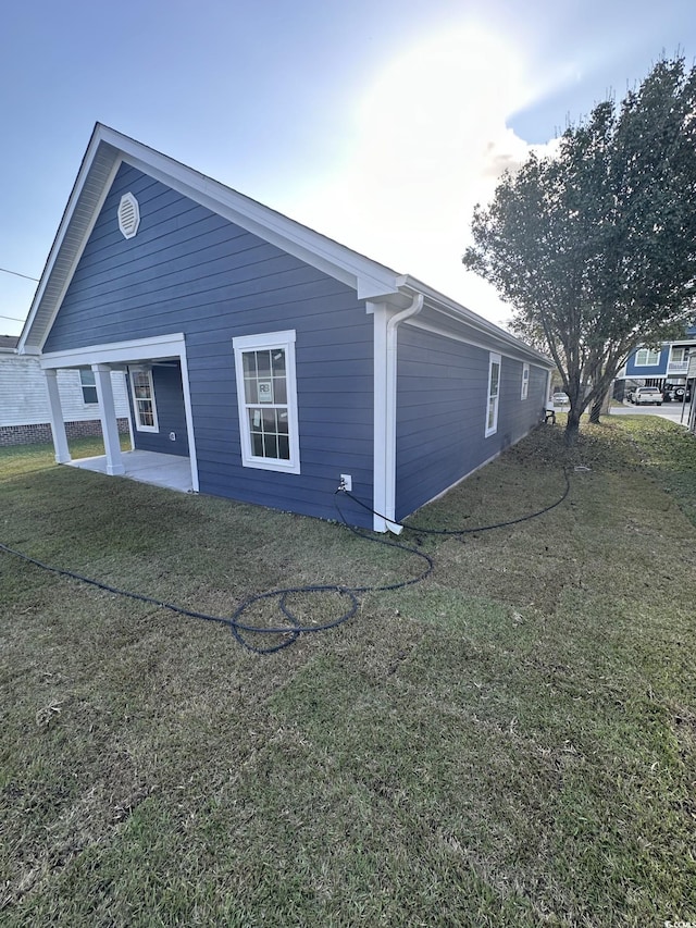 view of property exterior featuring a patio and a lawn