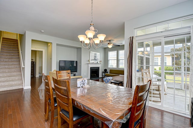 dining room with dark wood-type flooring and ceiling fan with notable chandelier