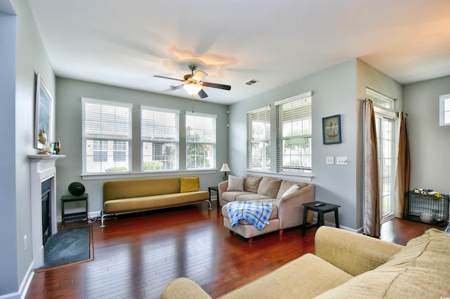 living room featuring dark hardwood / wood-style flooring, ceiling fan, and a wealth of natural light