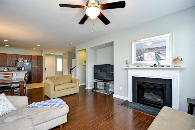 living room with ceiling fan and dark hardwood / wood-style floors