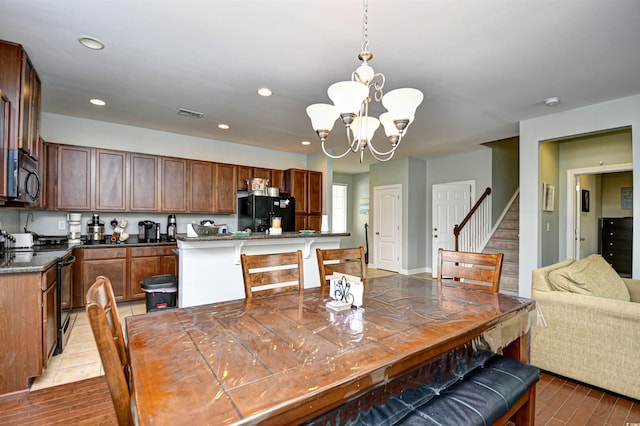 dining area with a notable chandelier and light hardwood / wood-style flooring