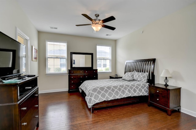 bedroom with multiple windows, dark wood-type flooring, and ceiling fan