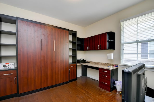 kitchen with built in desk, plenty of natural light, and dark hardwood / wood-style flooring