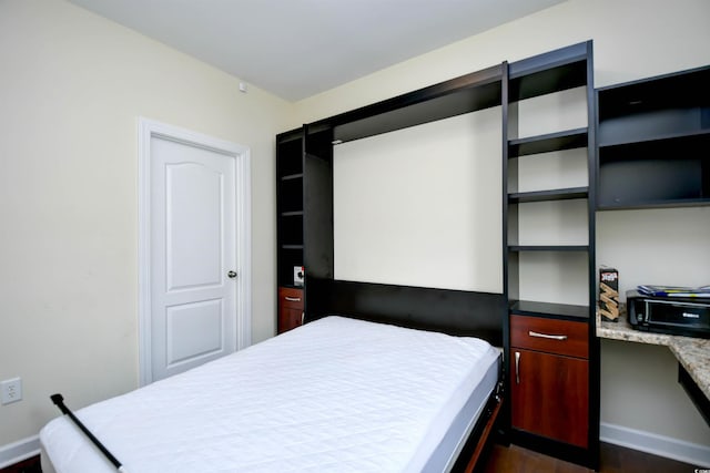 bedroom with dark hardwood / wood-style floors