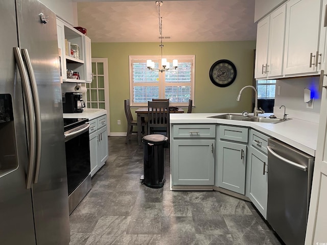 kitchen with appliances with stainless steel finishes, sink, decorative light fixtures, an inviting chandelier, and white cabinetry