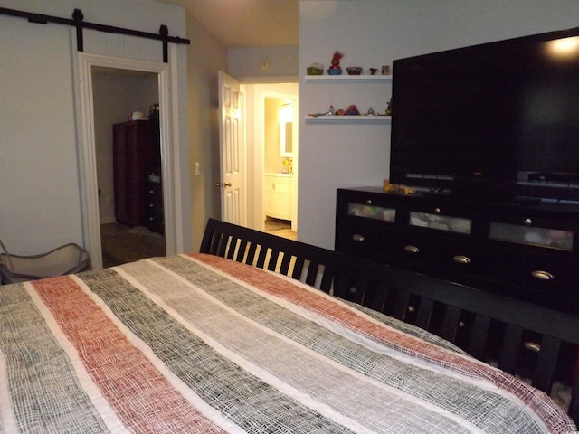 bedroom featuring a barn door and ensuite bathroom