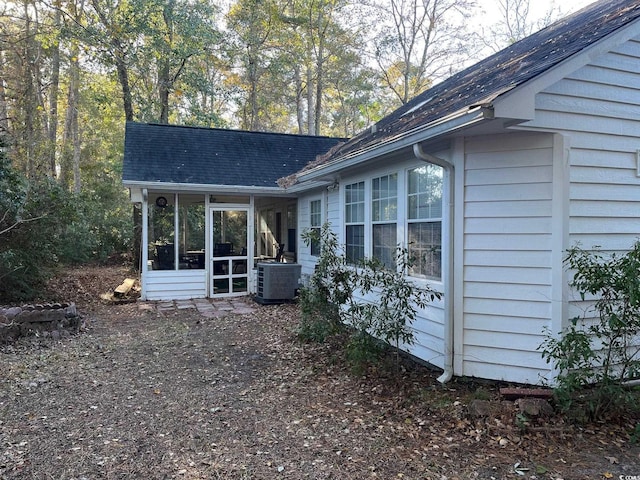 exterior space featuring central AC unit and a sunroom