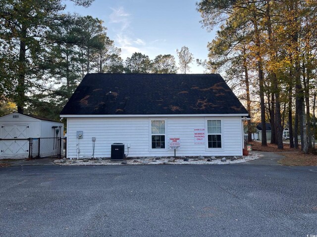 view of side of property with a shed and central AC unit