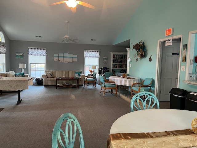 carpeted dining area with ceiling fan and lofted ceiling