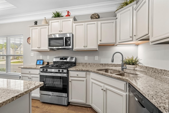 kitchen with crown molding, white cabinets, stainless steel appliances, and sink