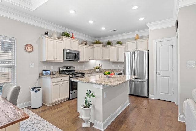 kitchen with crown molding, appliances with stainless steel finishes, and light hardwood / wood-style flooring