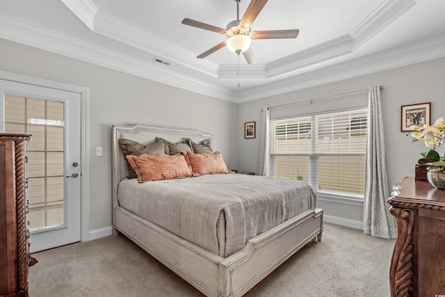 bedroom with ornamental molding, light colored carpet, a tray ceiling, and ceiling fan