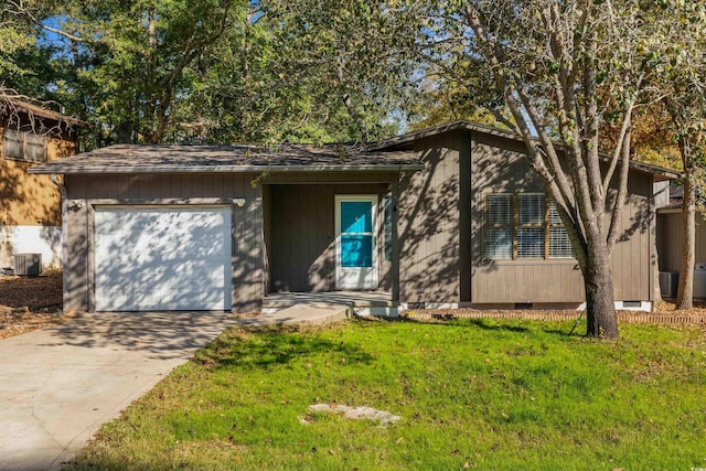 view of front of property featuring central air condition unit, a front yard, and a garage