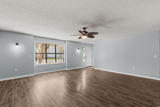 spare room with a textured ceiling, ceiling fan, and dark hardwood / wood-style flooring