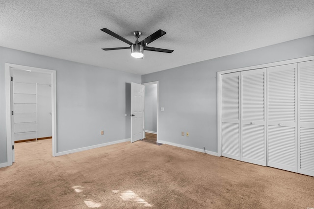 unfurnished bedroom featuring ceiling fan, a textured ceiling, and light colored carpet