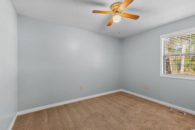 carpeted empty room with ceiling fan and a textured ceiling