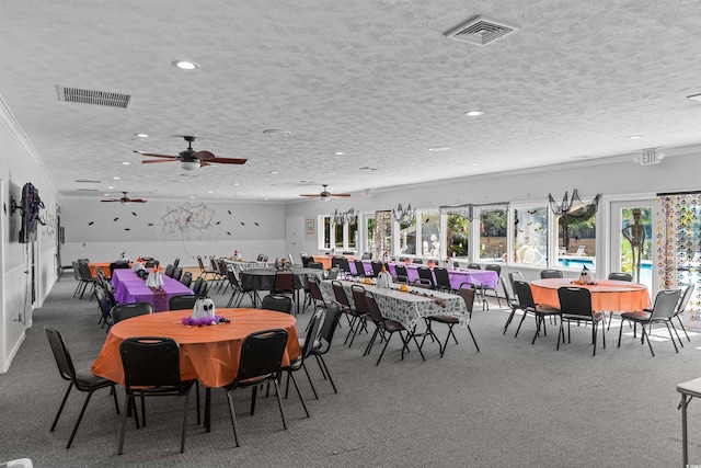 carpeted dining area featuring crown molding, a textured ceiling, and ceiling fan