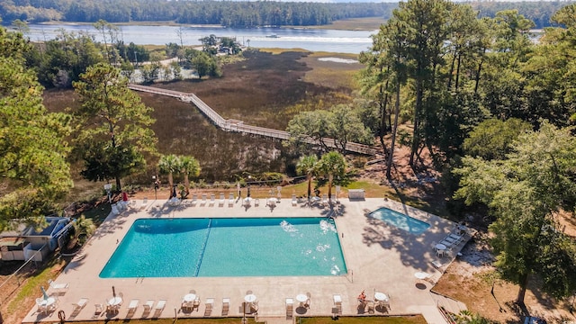 view of pool featuring a patio and a water view