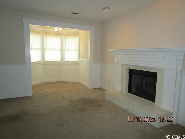 unfurnished living room with light colored carpet