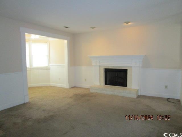 unfurnished living room featuring light colored carpet