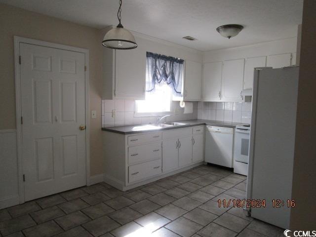 kitchen featuring backsplash, white cabinetry, hanging light fixtures, and white appliances