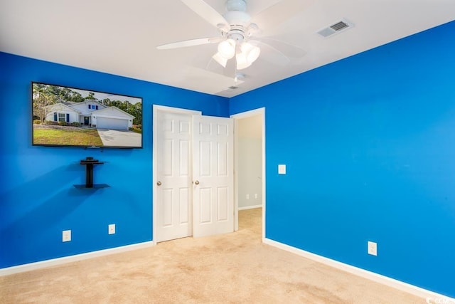 unfurnished bedroom featuring light carpet and ceiling fan