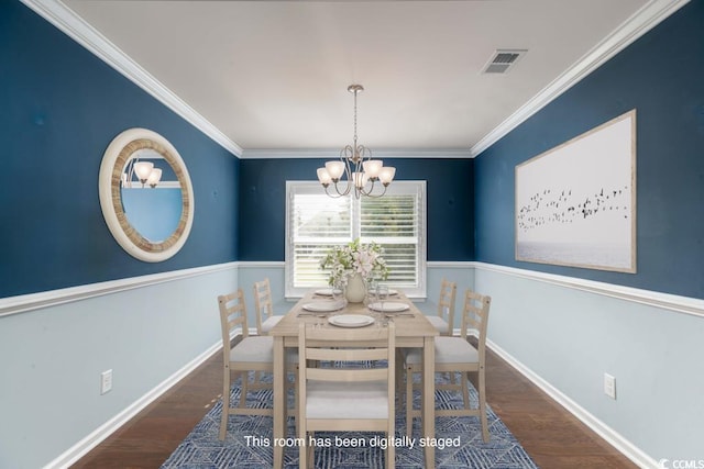 dining area featuring dark wood-type flooring, a chandelier, and ornamental molding