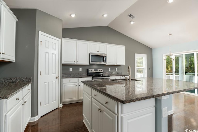 kitchen with white cabinetry, sink, stainless steel appliances, vaulted ceiling, and a center island with sink