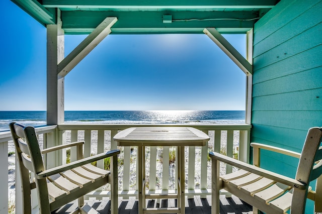 balcony featuring a water view and a beach view