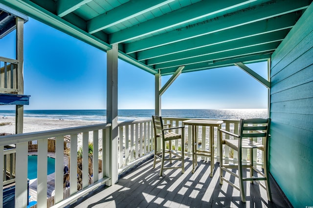 balcony featuring a view of the beach and a water view