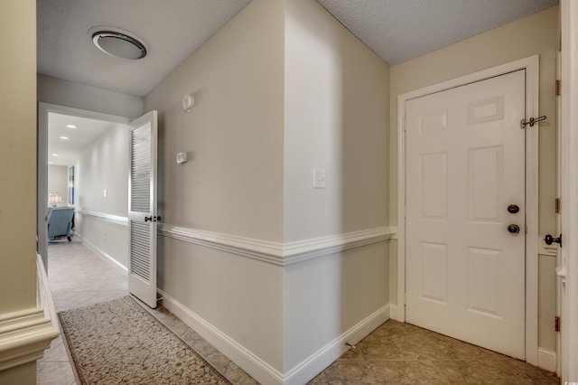 entryway featuring a textured ceiling and light tile patterned floors