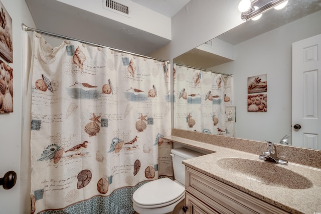 bathroom featuring toilet, walk in shower, and vanity