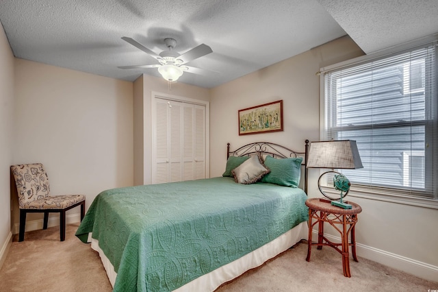 bedroom featuring light carpet, a closet, a textured ceiling, and ceiling fan