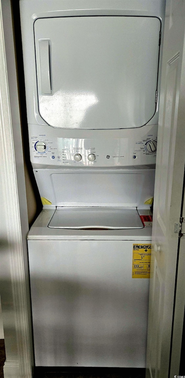 clothes washing area featuring stacked washer and dryer