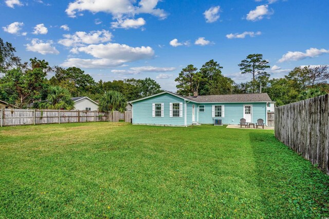 back of property with a yard, a patio area, and a fenced backyard
