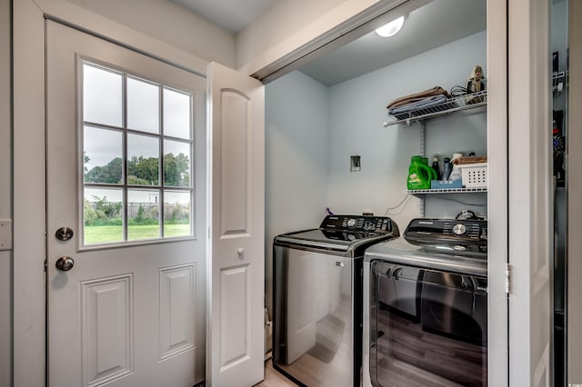 laundry area with washing machine and dryer and light wood-type flooring