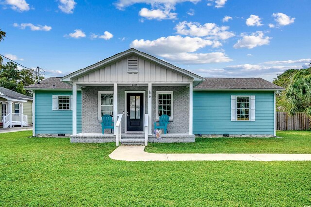 view of front of property with crawl space, fence, board and batten siding, a front yard, and a porch