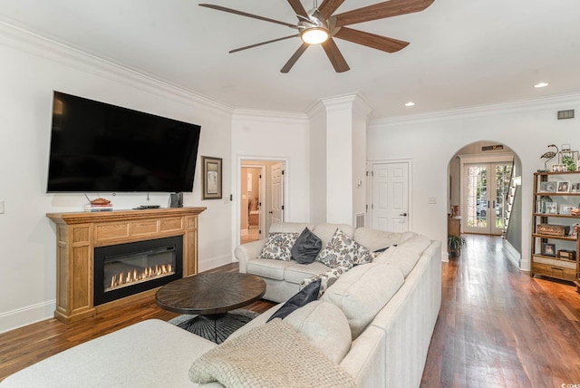 living room with arched walkways, ornamental molding, hardwood / wood-style floors, and baseboards