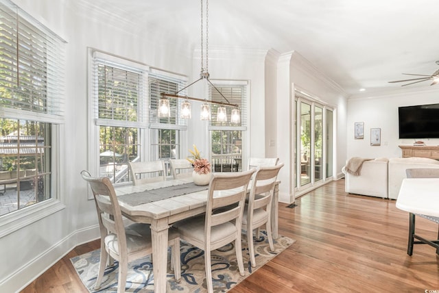 dining space featuring baseboards, ornamental molding, wood finished floors, and ceiling fan with notable chandelier