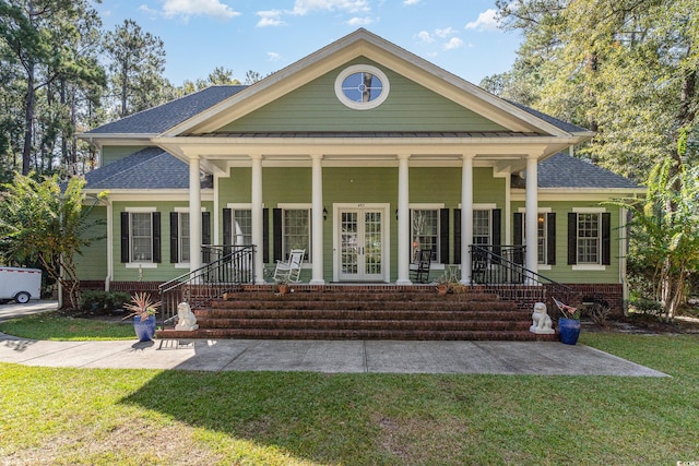 rear view of house featuring covered porch, french doors, and a lawn