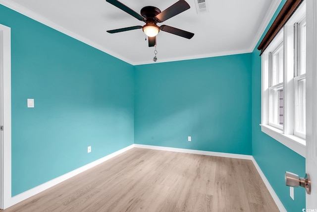 empty room featuring ceiling fan, light wood-type flooring, and crown molding