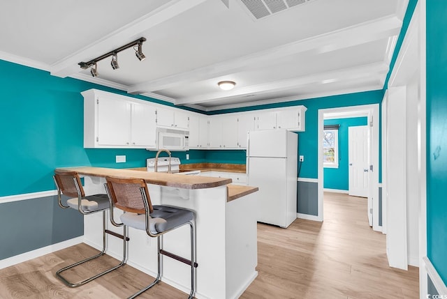 kitchen featuring white appliances, white cabinetry, light wood-type flooring, and kitchen peninsula