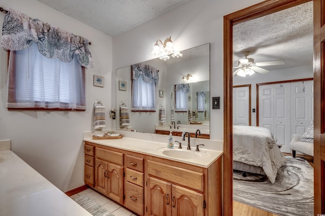 bathroom with a textured ceiling, ceiling fan, and plenty of natural light