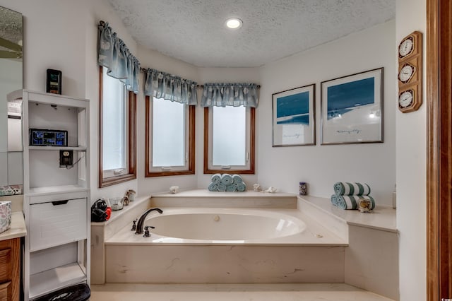 bathroom featuring a bathing tub, vanity, and a textured ceiling