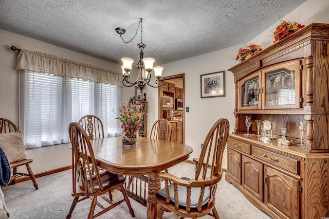 carpeted dining area with a textured ceiling and an inviting chandelier