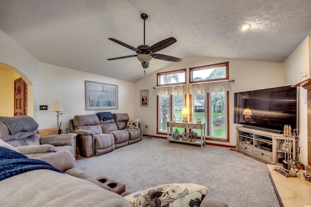 carpeted living room featuring vaulted ceiling, ceiling fan, and a textured ceiling