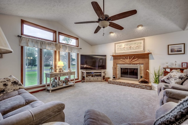 living room with a fireplace, a textured ceiling, carpet flooring, vaulted ceiling, and ceiling fan