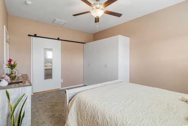 bedroom with a barn door, carpet floors, and ceiling fan