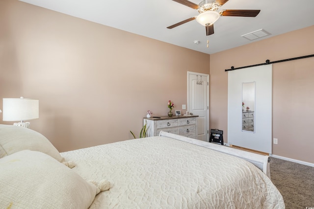 bedroom with a barn door, carpet flooring, and ceiling fan