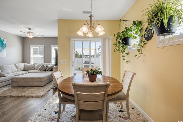 263 Red Maple Loop, Longs, SC 29568 - dining area featuring baseboards, wood finished floors, visible vents, and ceiling fan with notable chandelier